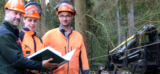 Matthias Hupfeld Matthias Stöber und Markus Frese im Wald beim Jammertal, im Hintergrund ein Holztransporter