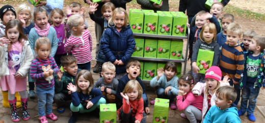 Kinder freuen sich über die Apfelsaftkartons