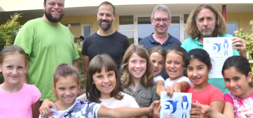 Kinder der Grundschule Bottendorf mit ihren Lehrern zeigen die Plakette und die Urkunde für ihr schwalbenfreundliches Schulgebäude
